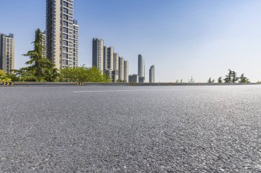 Panoramik siluet ve boş yolu, boş beton zemini olan modern iş binaları.