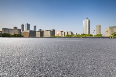 Panoramik siluet ve boş yolu, boş beton zemini olan modern iş binaları.