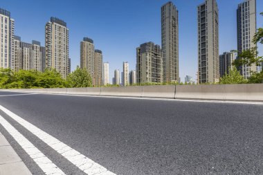 Panoramik siluet ve boş yolu, boş beton zemini olan modern iş binaları.