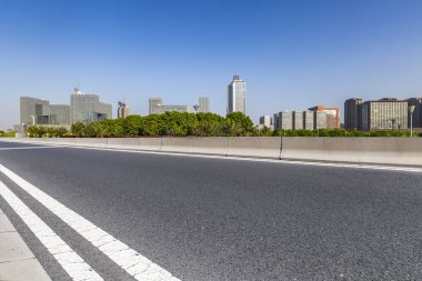 Panoramik siluet ve boş yolu, boş beton zemini olan modern iş binaları.