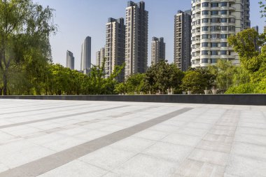 Panoramik siluet ve boş yolu, boş beton zemini olan modern iş binaları.