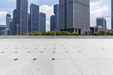 Panoramik siluet ve boş yolu, boş beton zemini olan modern iş binaları.