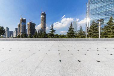 Panoramik siluet ve boş yolu, boş beton zemini olan modern iş binaları.