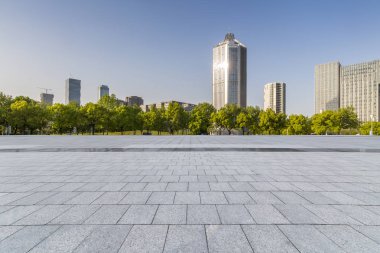 Panoramik siluet ve boş yolu, boş beton zemini olan modern iş binaları.