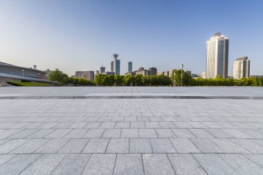 Panoramik siluet ve boş yolu, boş beton zemini olan modern iş binaları.