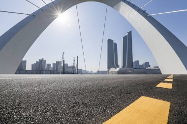 Panoramik siluet ve boş yolu, boş beton zemini olan modern iş binaları.