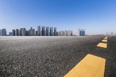 Panoramik siluet ve boş yolu, boş beton zemini olan modern iş binaları.