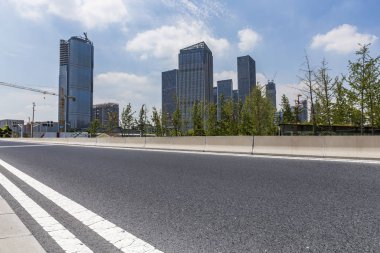 Panoramik siluet ve boş yolu, boş beton zemini olan modern iş binaları.