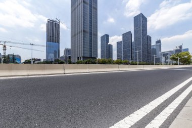 Panoramik siluet ve boş yolu, boş beton zemini olan modern iş binaları.