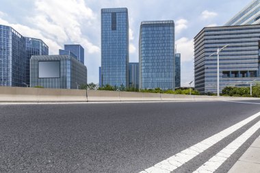 Panoramik siluet ve boş yolu, boş beton zemini olan modern iş binaları.