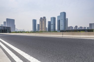 Panoramik siluet ve boş yolu, boş beton zemini olan modern iş binaları.