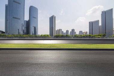 Panoramik siluet ve boş yolu, boş beton zemini olan modern iş binaları.