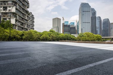 Panoramik siluet ve boş yolu, boş beton zemini olan modern iş binaları.