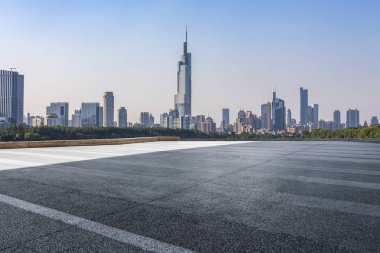 Panoramik siluet ve boş yolu, boş beton zemini olan modern iş binaları.