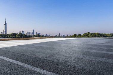 Panoramik siluet ve boş yolu, boş beton zemini olan modern iş binaları.