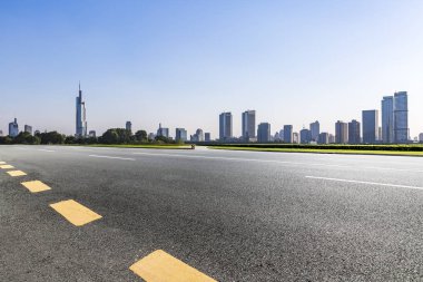 Panoramik siluet ve boş yolu, boş beton zemini olan modern iş binaları.
