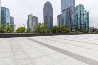 Panoramik siluet ve boş yolu, boş beton zemini olan modern iş binaları.