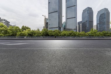 Panoramik siluet ve boş yolu, boş beton zemini olan modern iş binaları.
