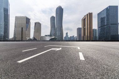 Panoramik siluet ve boş yolu, boş beton zemini olan modern iş binaları.