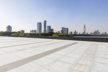 Panoramik siluet ve boş yolu, boş beton zemini olan modern iş binaları.