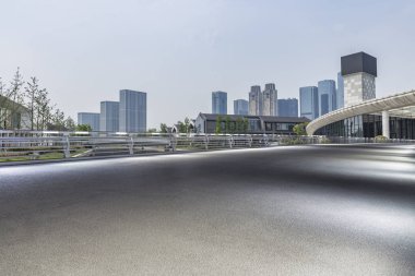 Panoramik siluet ve boş yolu, boş beton zemini olan modern iş binaları.