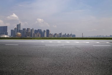 Panoramik siluet ve boş yolu, boş beton zemini olan modern iş binaları.
