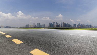 Panoramik siluet ve boş yolu, boş beton zemini olan modern iş binaları.