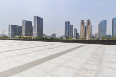 Panoramik siluet ve boş yolu, boş beton zemini olan modern iş binaları.
