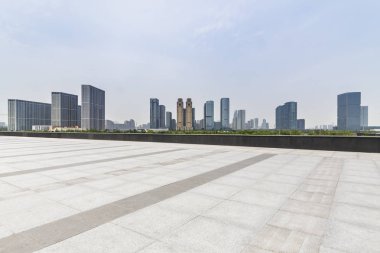 Panoramik siluet ve boş yolu, boş beton zemini olan modern iş binaları.