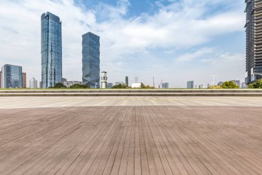 Panoramik siluet ve boş yolu, boş beton zemini olan modern iş binaları.