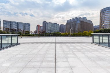 Panoramik siluet ve boş yolu, boş beton zemini olan modern iş binaları.