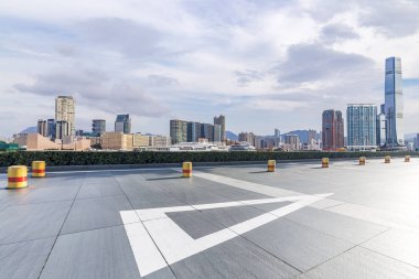Panoramik siluet ve boş yolu, boş beton zemini olan modern iş binaları.
