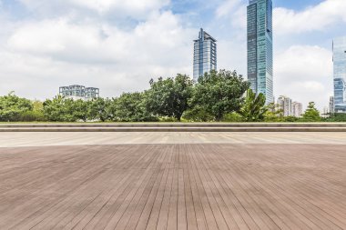 Panoramik siluet ve boş yolu, boş beton zemini olan modern iş binaları.