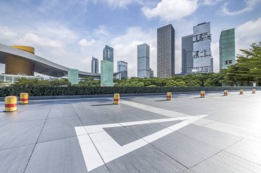 Panoramik siluet ve boş yolu, boş beton zemini olan modern iş binaları.
