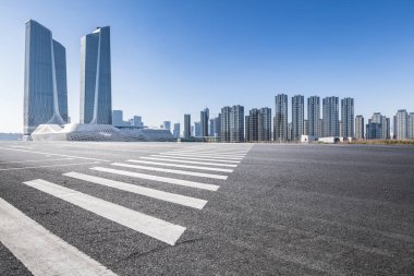Panoramik siluet ve boş yolu, boş beton zemini olan modern iş binaları.