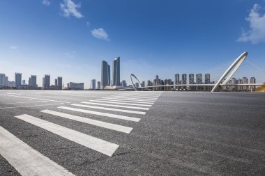 Panoramik siluet ve boş yolu, boş beton zemini olan modern iş binaları.