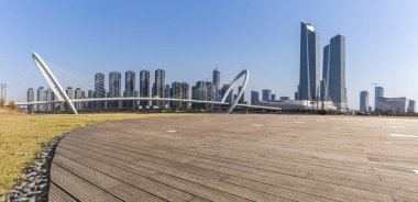 Panoramik siluet ve boş yolu, boş beton zemini olan modern iş binaları.