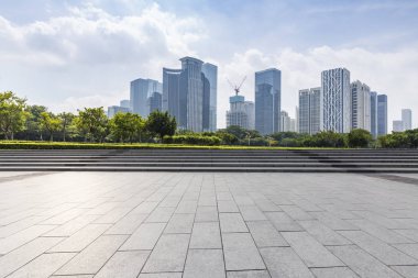 Panoramik siluet ve boş yolu, boş beton zemini olan modern iş binaları.