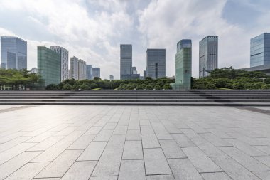Panoramik siluet ve boş yolu, boş beton zemini olan modern iş binaları.