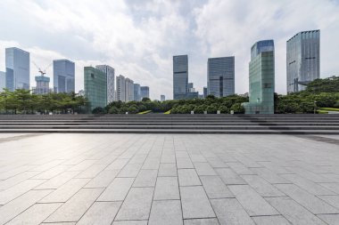 Panoramik siluet ve boş yolu, boş beton zemini olan modern iş binaları.