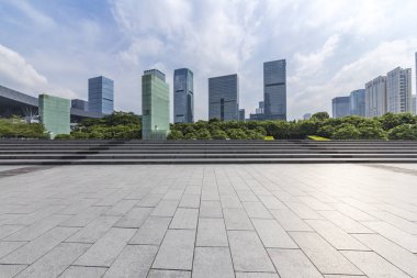 Panoramik siluet ve boş yolu, boş beton zemini olan modern iş binaları.