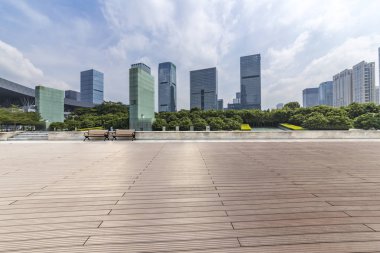 Panoramik siluet ve boş yolu, boş beton zemini olan modern iş binaları.