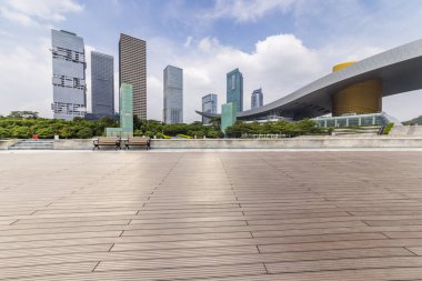 Panoramik siluet ve boş yolu, boş beton zemini olan modern iş binaları.