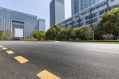 Panoramik siluet ve boş yolu, boş beton zemini olan modern iş binaları.