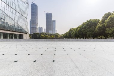 Panoramik siluet ve boş yolu, boş beton zemini olan modern iş binaları.