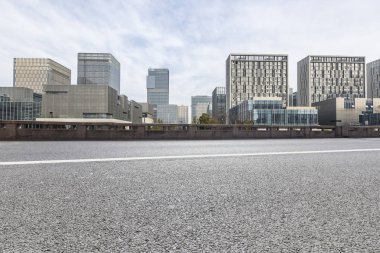 Panoramik siluet ve boş yolu, boş beton zemini olan modern iş binaları.