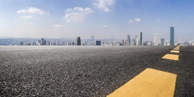 Panoramik siluet ve boş yolu, boş beton zemini olan modern iş binaları.
