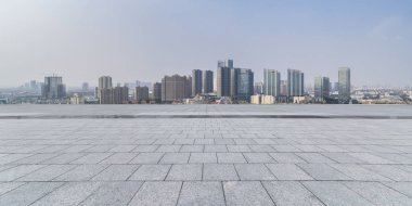 Panoramik siluet ve boş yolu, boş beton zemini olan modern iş binaları.