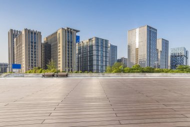 Panoramik siluet ve boş yolu, boş beton zemini olan modern iş binaları.