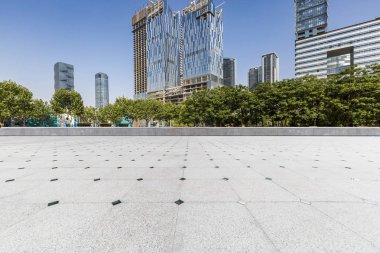 Panoramik siluet ve boş yolu, boş beton zemini olan modern iş binaları.